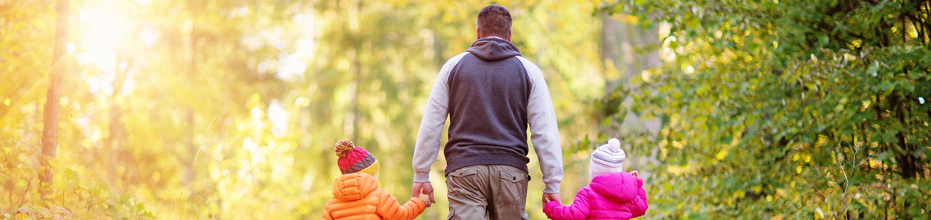 Father and two children walking in woods