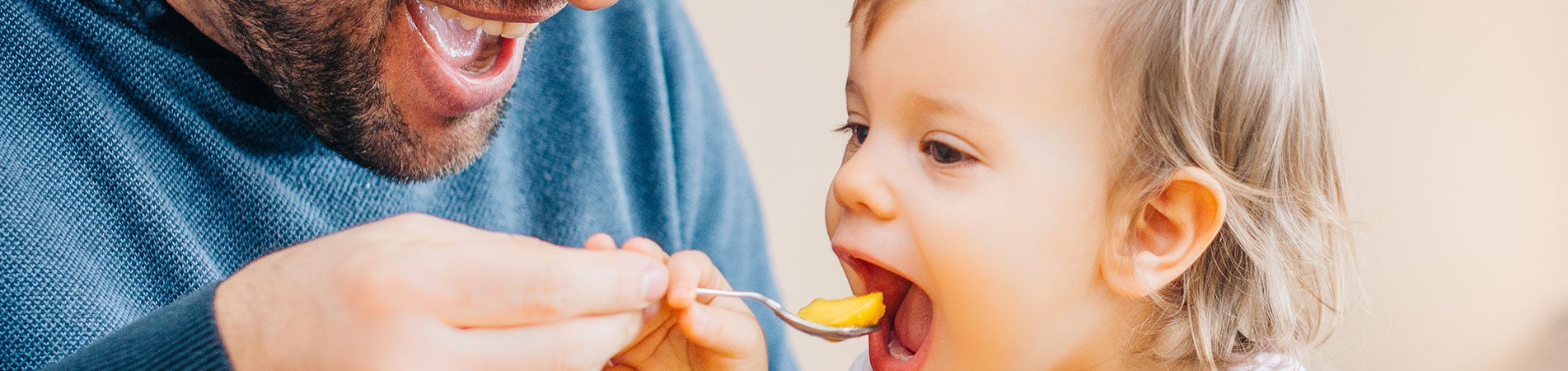 Father feeding young Daughter